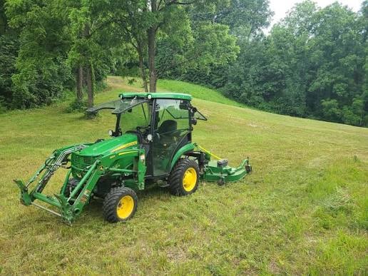 Tractor mowing hillside — land management